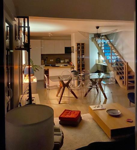 Il comprend un salon avec une table et une cuisine avec un escalier. dans l'établissement Duplex terrasse à Clichy, Hauts de Seine, à Clichy