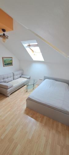 a white bedroom with a bed and a couch at Studio Dani in Mostar