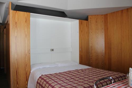 Habitación pequeña con cama y ventana en Residence Albarè en Mezzana