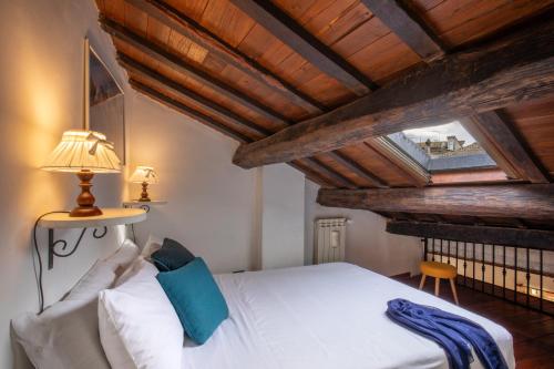 1 dormitorio con cama blanca y techo de madera en Centro e Spiaggia ambra, en Anguillara Sabazia