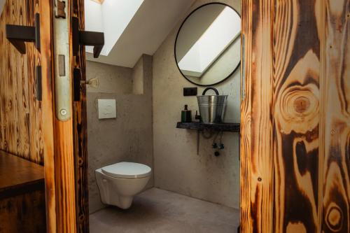 a small bathroom with a toilet and a mirror at Dom nad jeziorem Mazury - Pod Napięciem in Mrągowo