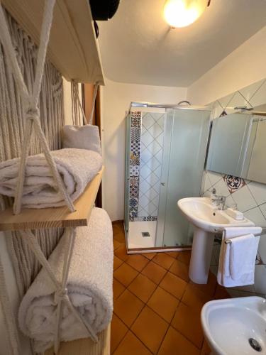 a bathroom with a bed and a sink and a shower at Gioia di Mare in Marzamemi