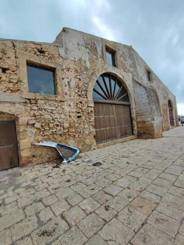 an old stone building with a door and a window at Gioia di Mare in Marzamemi
