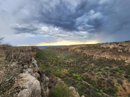 a view of a canyon with a rainbow in the sky at Munsterland Guest Farm in Outjo
