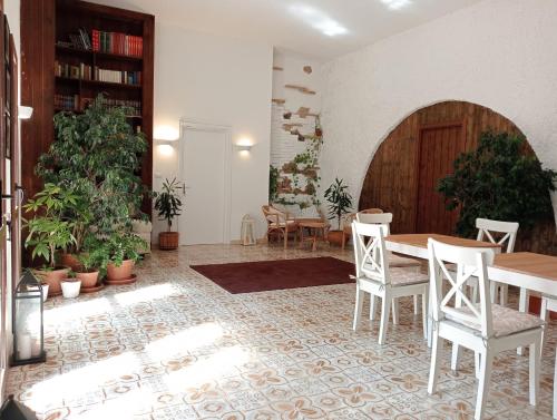 een eetkamer met een tafel en stoelen en planten bij Gli Archi Country Home in Giurdignano