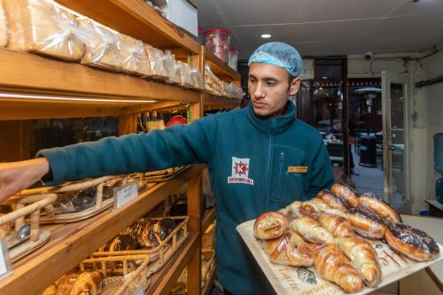 a man is reaching for a shelf of bread at Aawas Boutique Hotel in Kathmandu