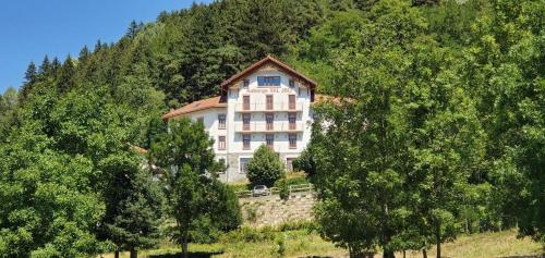 a large building on top of a hill with trees at Location Paradiski San Bernardo in Séez