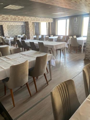 a dining room with white tables and chairs at Werrapark Aktiv Hotel Am Sommerberg in Masserberg