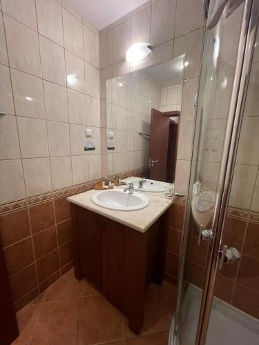 a bathroom with a sink and a shower with a mirror at Lux By Kaliakria in Topola