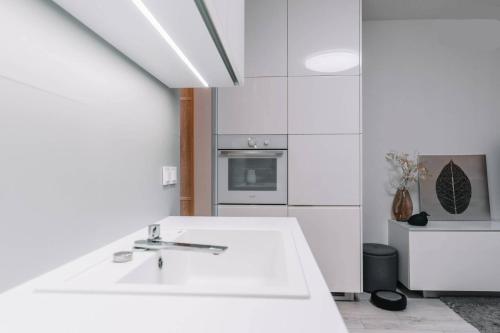 a white kitchen with a sink and an oven at E3 Luxury OldTown Apt w Free Garage, Supermarket, FastWifi, Unlimited Music, Prime Video, Aircon in Košice