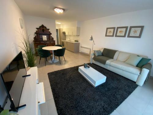 sala de estar con sofá y mesa en Gezellig modern appartement met optie garagebox en in de buurt van strand, winkels en restaurants en Ostende