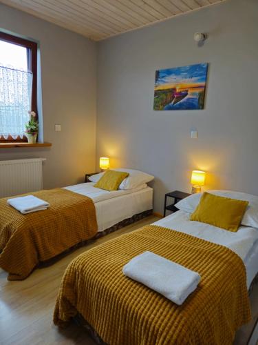 two beds in a hotel room with two bedsskirts at Bingo in Powidz