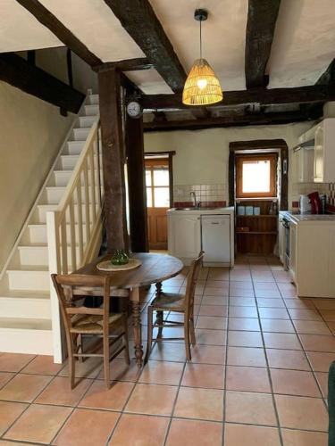 une cuisine avec une table et des chaises dans une pièce dans l'établissement Maison médiévale climatisée avec jardin, à Monpazier
