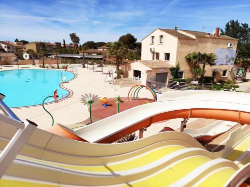 a large swimming pool with a slide at a resort at Mobil-Home Valras plage in Valras-Plage