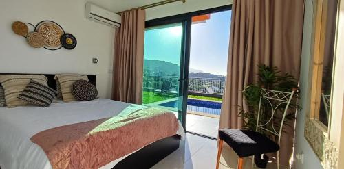 1 dormitorio con 1 cama y balcón con vistas. en The Tree of Life House, en Ponta do Sol
