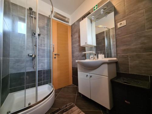 a bathroom with a shower and a sink and a tub at Downtown Apartment Bepi in Opatija