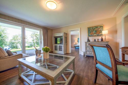 a living room with a glass table and a couch at Marina Hotel am Starnberger See in Bernried