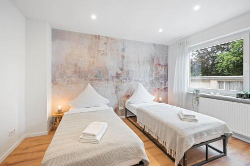 2 camas en una habitación blanca con ventana en Casa Aguila 2.0, en Viernheim