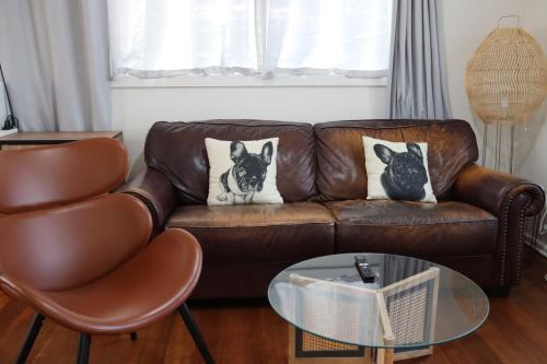 un sofá de cuero marrón con dos perros en las almohadas en Timeless Allure near Ringwood, en Heathmont
