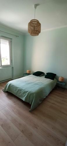 - une chambre avec un grand lit vert dans l'établissement Le paradis face au marché, à La Rochelle