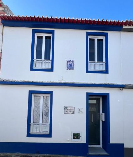 a white house with blue windows and a door at Esplanada do Ilhéu in Vila Franca do Campo