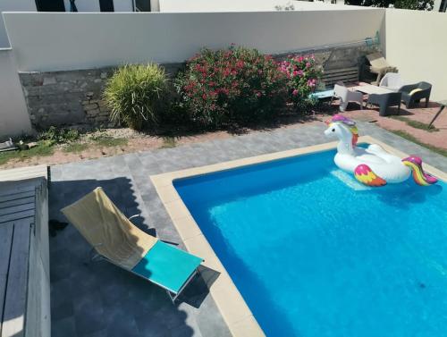 - une piscine avec deux canards en caoutchouc dans l'eau dans l'établissement Grand gîte - avec grande piscine - au calme, à Charron