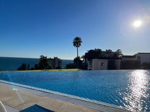 une grande piscine avec vue sur l'océan dans l'établissement Superbe appartement une chambre vue mer piscine tennis, à Cannes