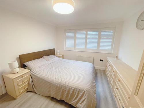 a white bedroom with a bed and a window at Home near London Heathrow, Slough,Windsor,Legoland in Colnbrook