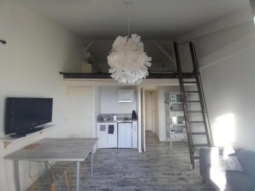 - un salon avec une échelle et un lustre dans l'établissement APPARTEMENT 55M2 MAS DE LA MISERICORDE, à Perpignan