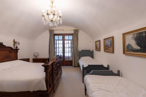 een slaapkamer met 2 bedden en een kroonluchter bij Cabana & le Fort - Proche Stations de Ski Les 3 Vallées in Mercury