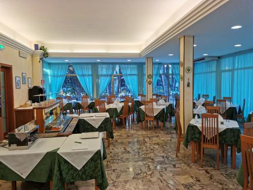 een restaurant met tafels en stoelen en een kerstboom bij Hotel Pine Beach in Rosolina Mare