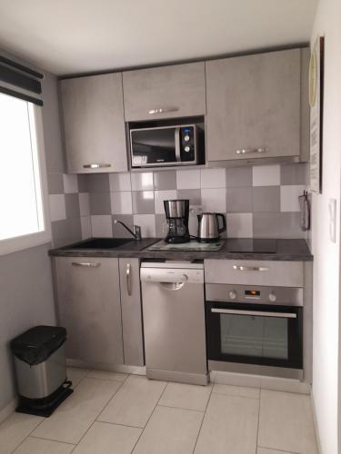 une cuisine avec des appareils en acier inoxydable et un micro-ondes dans l'établissement Le Nid de Pie, à Le Russey