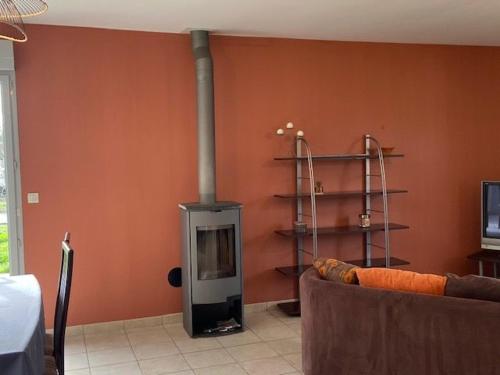 sala de estar con chimenea y sofá en lemarinel, en Barneville-Carteret