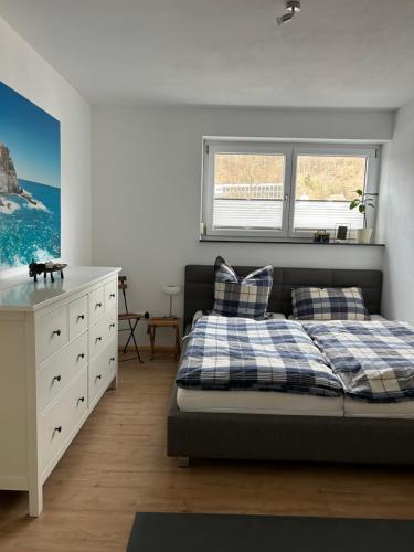 ein Schlafzimmer mit einem Bett, einer Kommode und einem Fenster in der Unterkunft Cube - Ferienhaus mit Garten und Terrasse in Eberbach in Eberbach