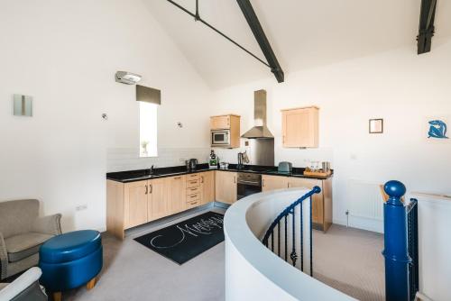 a kitchen with a staircase leading to a living room at Mannings Hotel in Truro