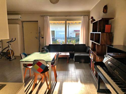 een woonkamer met een bank, een tafel en een piano bij Casa - La Masca - Alla porta delle Langhe in Cherasco