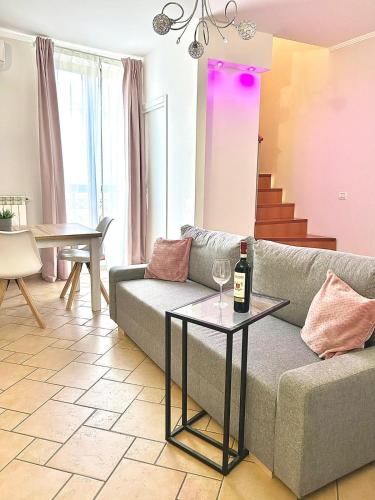 soggiorno con divano e tavolo con bottiglia di vino di RESIDENCE VIOLA a Foggia