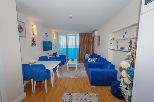 a living room with blue chairs and a table at 0rbi City Luxury Suites in Batumi