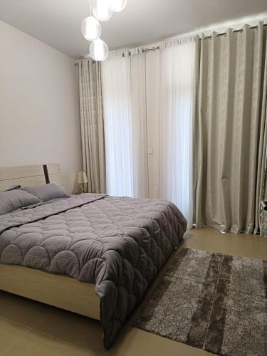 a bedroom with a large bed with curtains and a rug at Muscat Bay in Bandar Jişşah