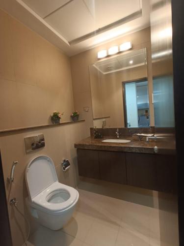 a bathroom with a toilet and a sink and a mirror at Muscat Bay in Bandar Jişşah