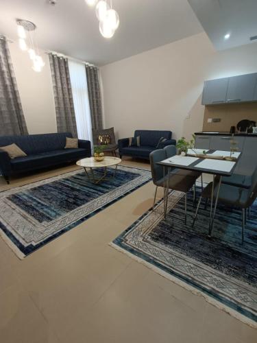 a living room with couches and tables and rugs at Muscat Bay in Bandar Jişşah
