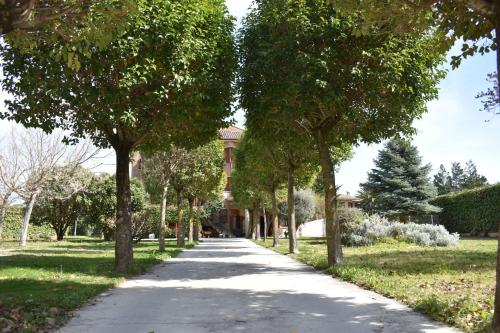 a path through a park with trees and a building at Casa Gilgar Olite in Olite
