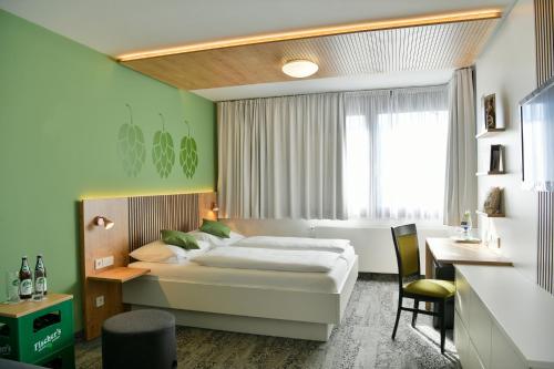 メッシンゲンにあるフィッシャーズ ホテル ブラウハウスのベッドとデスクが備わるホテルルームです。