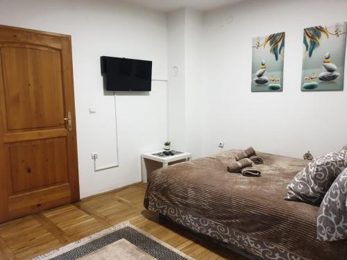 a bedroom with a bed and a flat screen tv at Apartman Dreams in Novi Sad