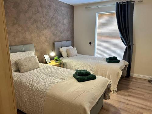 a bedroom with two beds with green towels on them at Auckland House 3 beds free parking in Doncaster