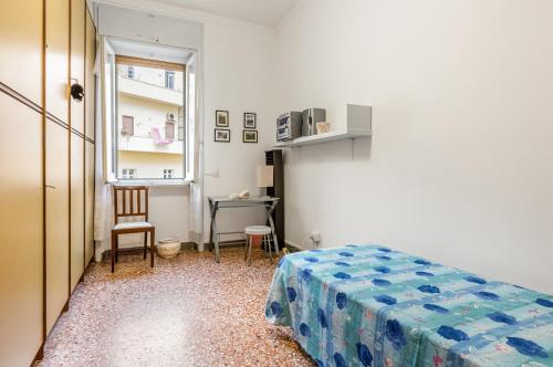 1 dormitorio con cama, escritorio y ventana en Cagliari - Central & Roomy Apartment with Balcony!, en Cagliari