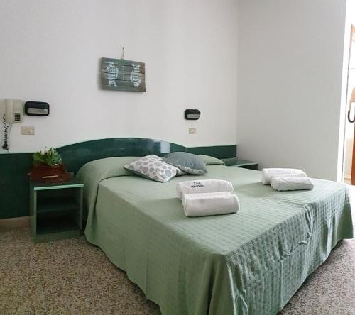 una camera da letto con un letto e due asciugamani di Hotel Concordia Palace a Rimini