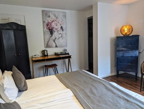 a bedroom with a bed and a dresser and a desk at Chambres d'Hôtes La Filature in Saint-Quentin