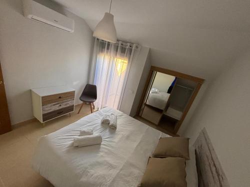 ein Schlafzimmer mit einem großen weißen Bett und einem Spiegel in der Unterkunft Duplex entre molinos in Consuegra