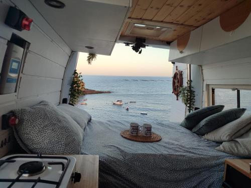 a bed in an rv with a view of the ocean at Sleepfurgo in Las Palmas de Gran Canaria
